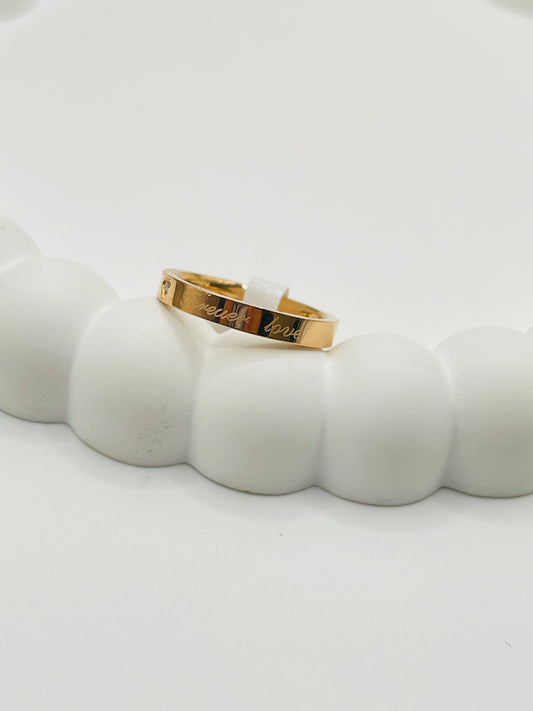 Rose Gold ring with engraved text on a white surface