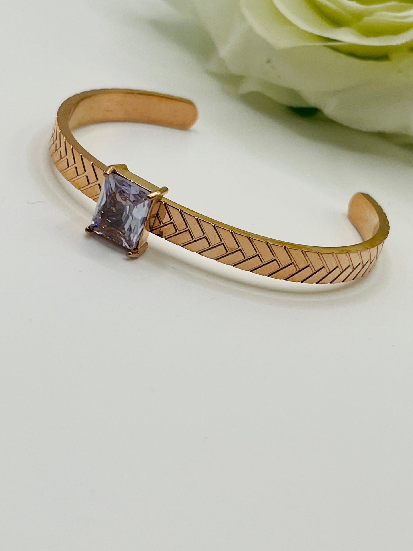 Rose Gold bracelet with a purple gemstone on a light background
