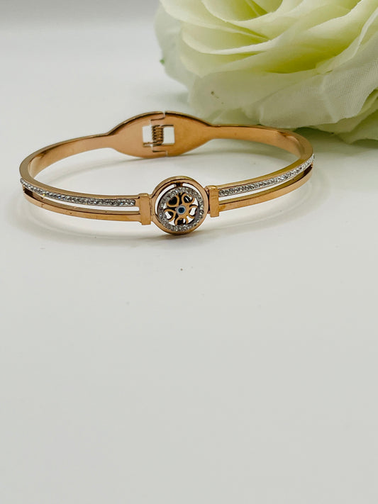 Evil eyeRose Gold bracelet/bangle with a decorative clasp on a light background