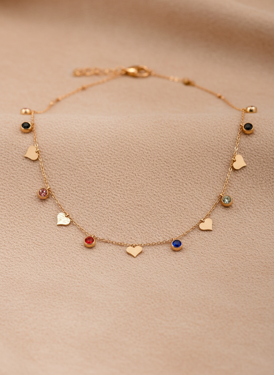 Delicate rose gold necklace with heart and gemstone charms on a beige background