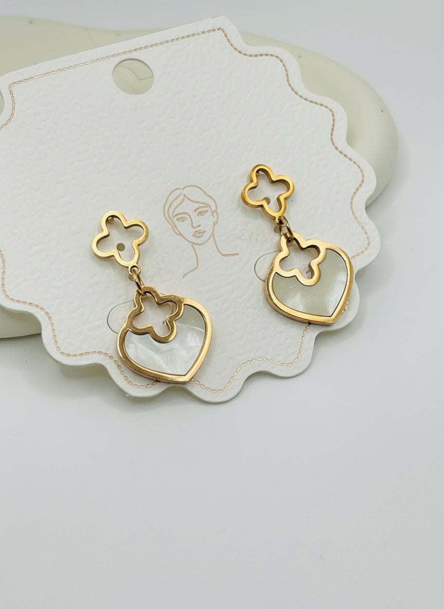 Pair of rose gold and heart-shaped earrings on a branded card with a light gray background