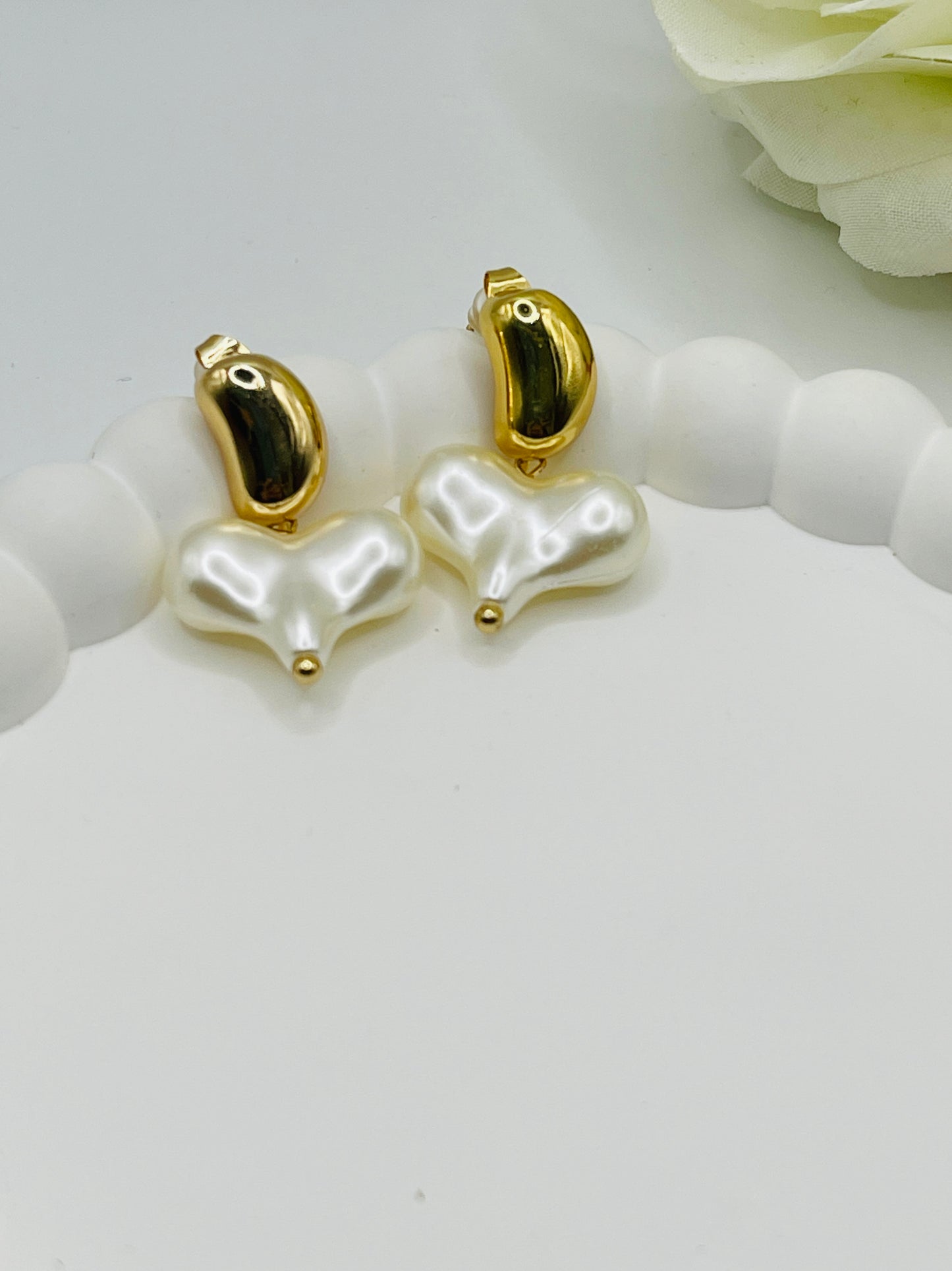 Pearl earrings with gold accents on a white surface