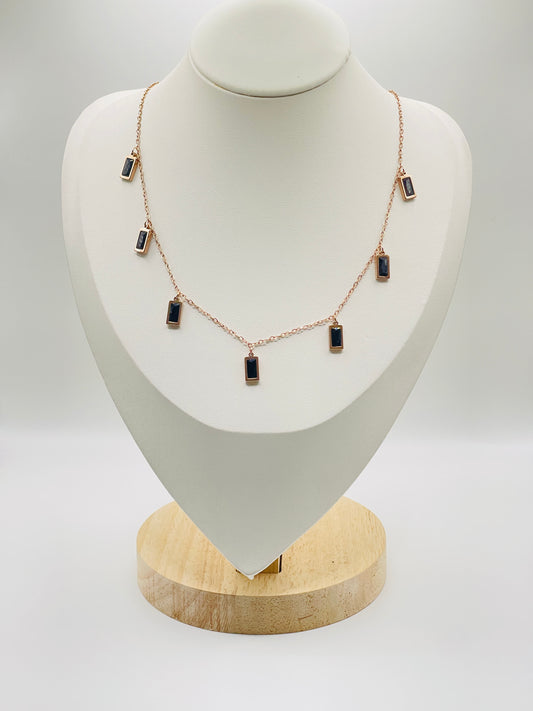 Rose gold Necklace with black stones on a white mannequin bust