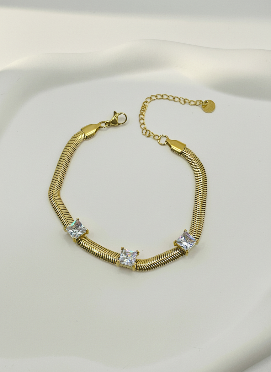Gold bracelet with clear stones on a white background