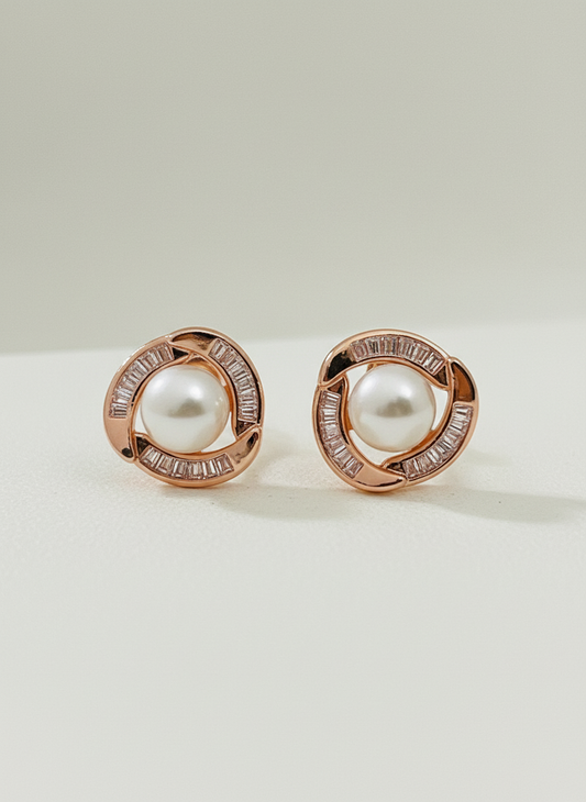 Pair of rose gold earrings with pearls on a light background