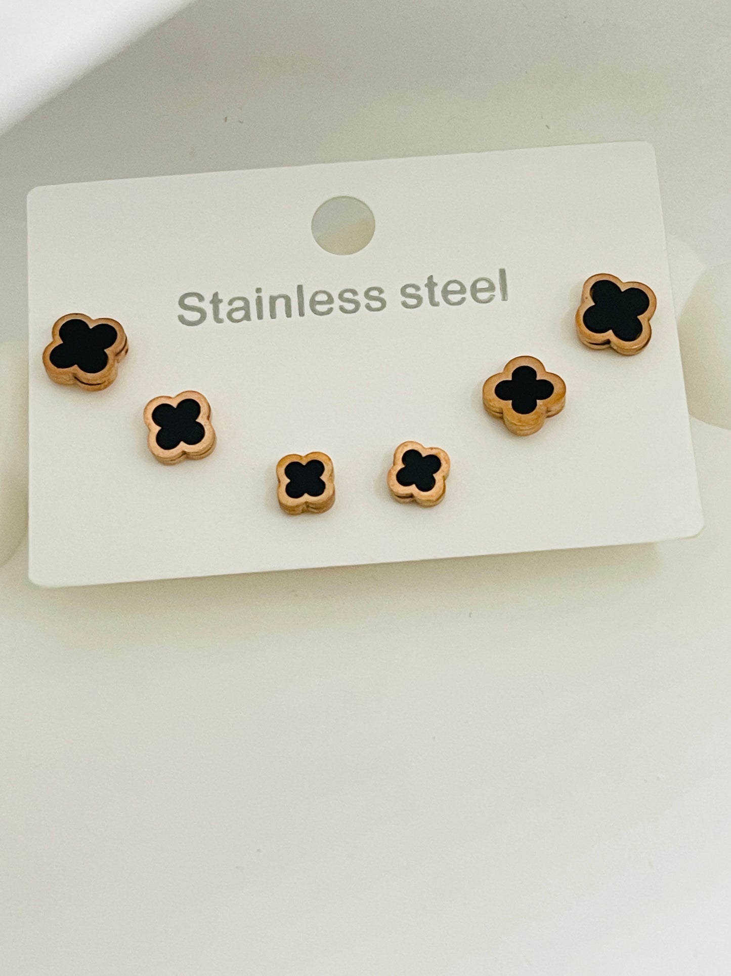 Set of stainless steel flower-shaped earrings on a white card with 'Stainless steel' text.