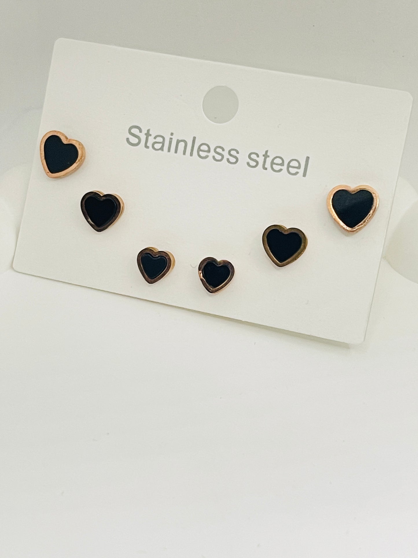 Set of heart-shaped earrings on a white card with 'Stainless steel' text.