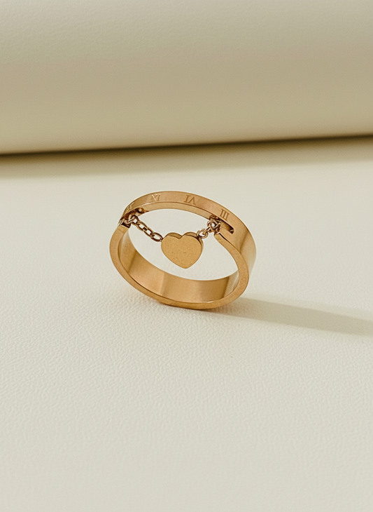Rose Gold ring with a heart charm on a beige background