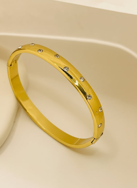 Gold bracelet with small stones on a white background