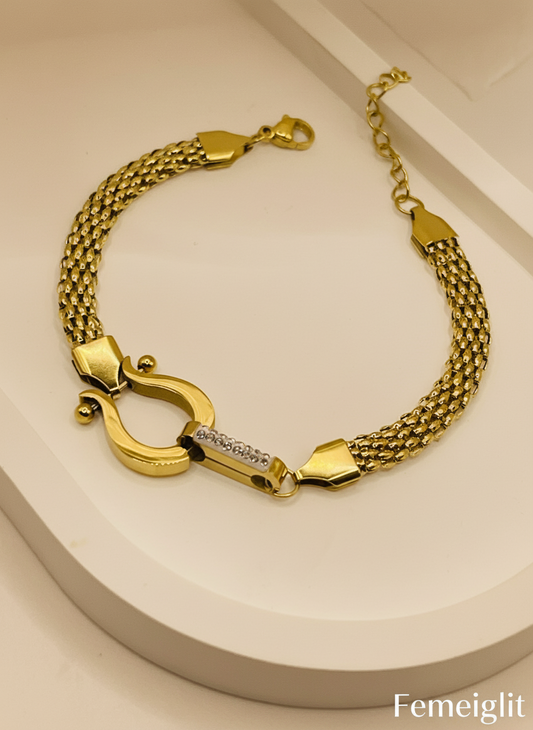 Gold bracelet with a clasp on a beige background