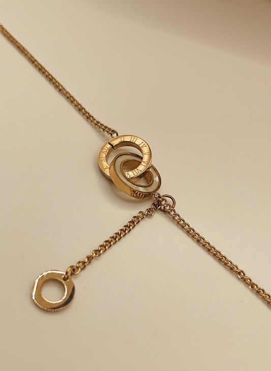 Rose gold chain bracelet
with interlocking rings on a light gray background