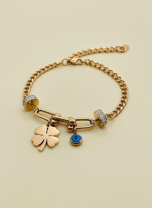 Rose Gold chain bracelet with charms on a white stand