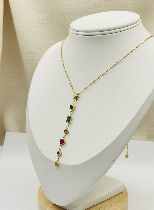 Gold necklace with colored gemstones on a white stand