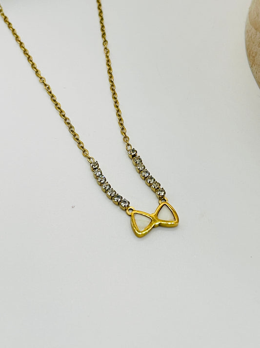Gold necklace with a unique pendant on a light gray background