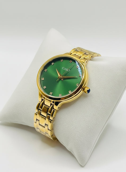 Gold wristwatch with green face on a white cushion