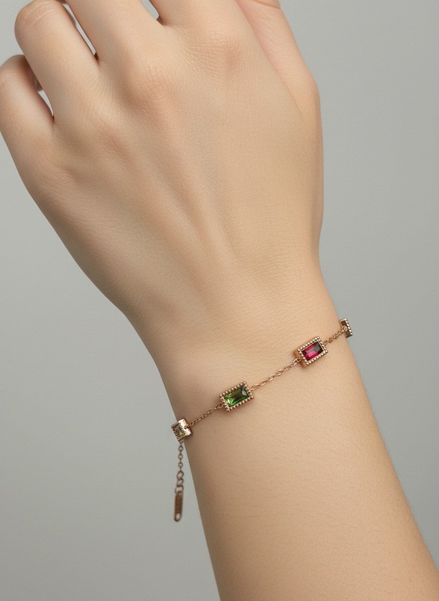 Gold bracelet with gemstone accents on a light background