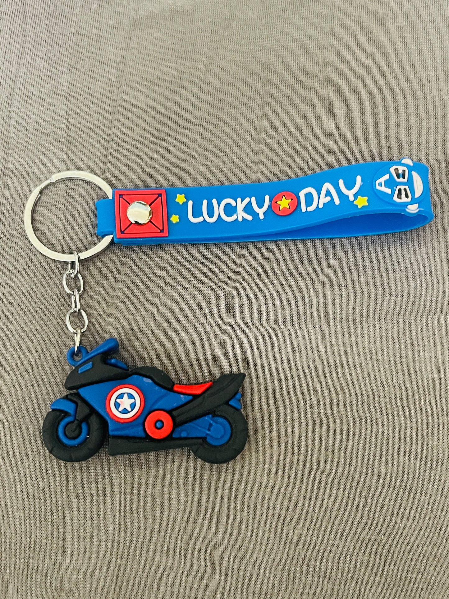 Keychain with a motorcycle design and 'LUCKY DAY' text on a gray background