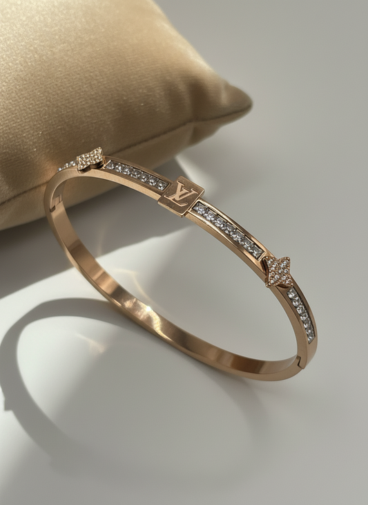 Rose Gold bracelet with diamond accents on a gray background