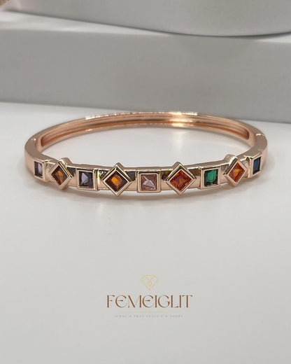 Rose gold bracelet with colorful gemstones on a white background, featuring the brand 'Femeiglit'.
