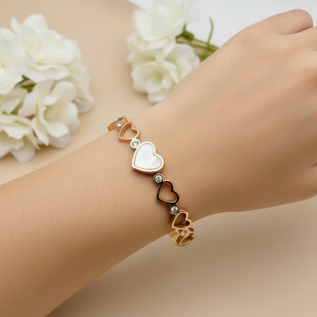 Rose gold bracelet with heart designs on a light background