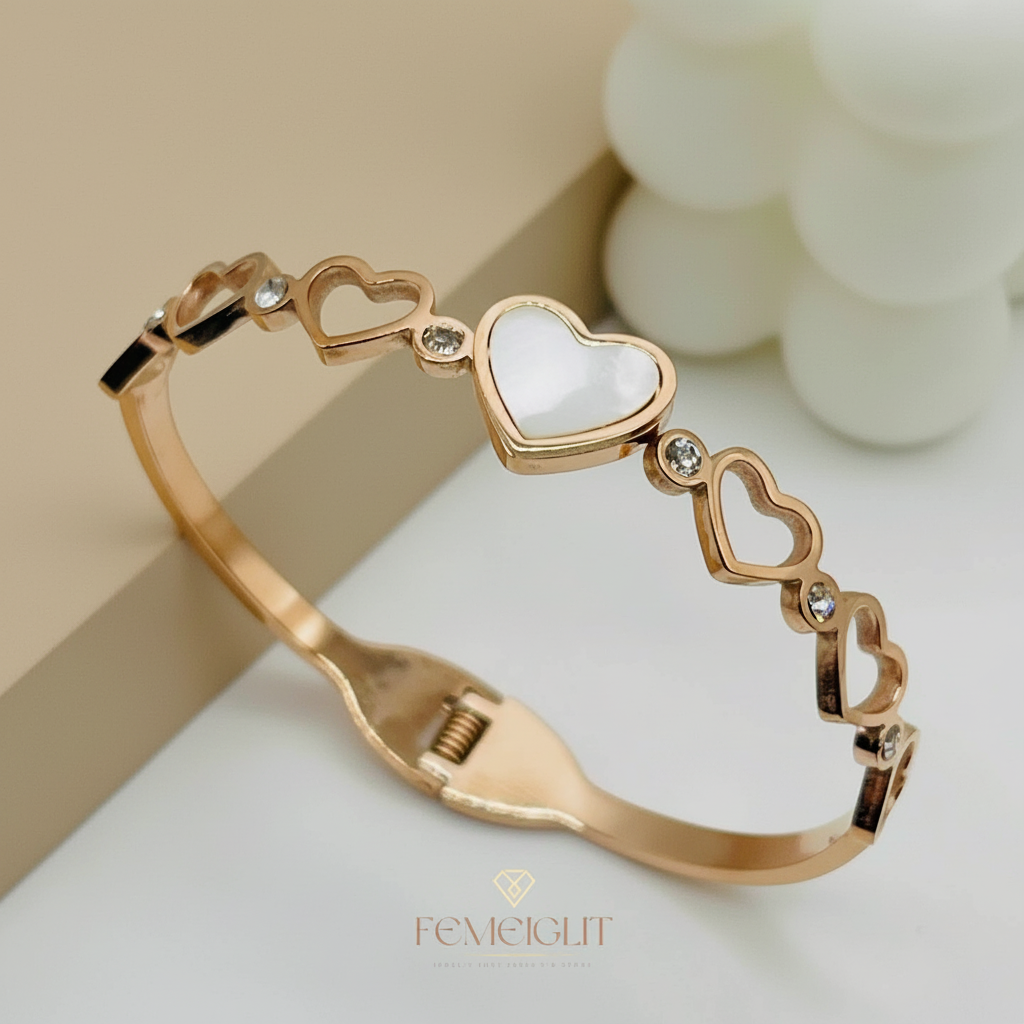 Rose gold bracelet with heart designs on a light background