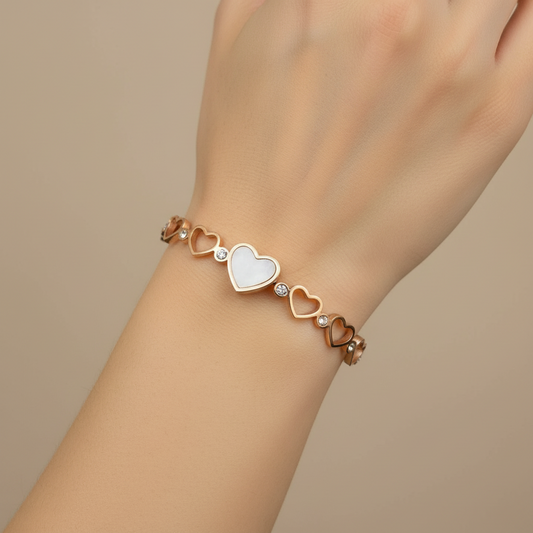 Rose gold bracelet with heart designs on a light background