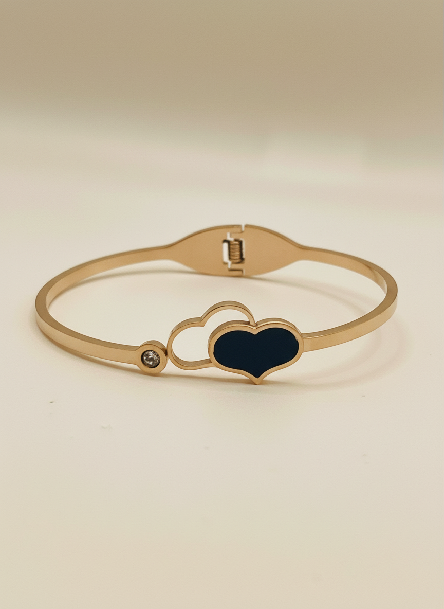 Rose gold bracelet with a heart-shaped black stone on a light gray background, featuring the brand 'FEMEIGLIT'.