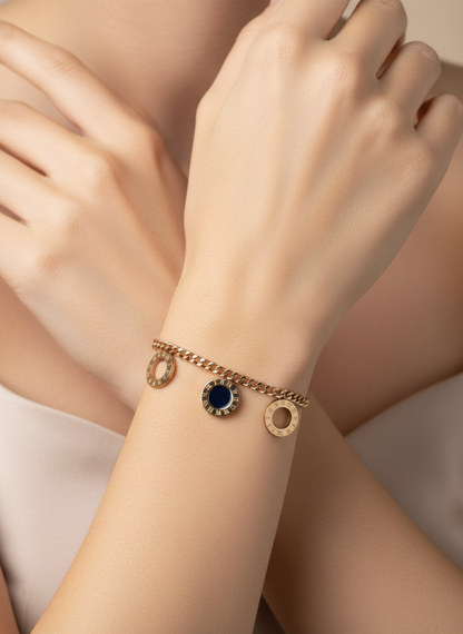 Rose Gold bracelet with a blue gemstone on a person's wrist against a neutral background