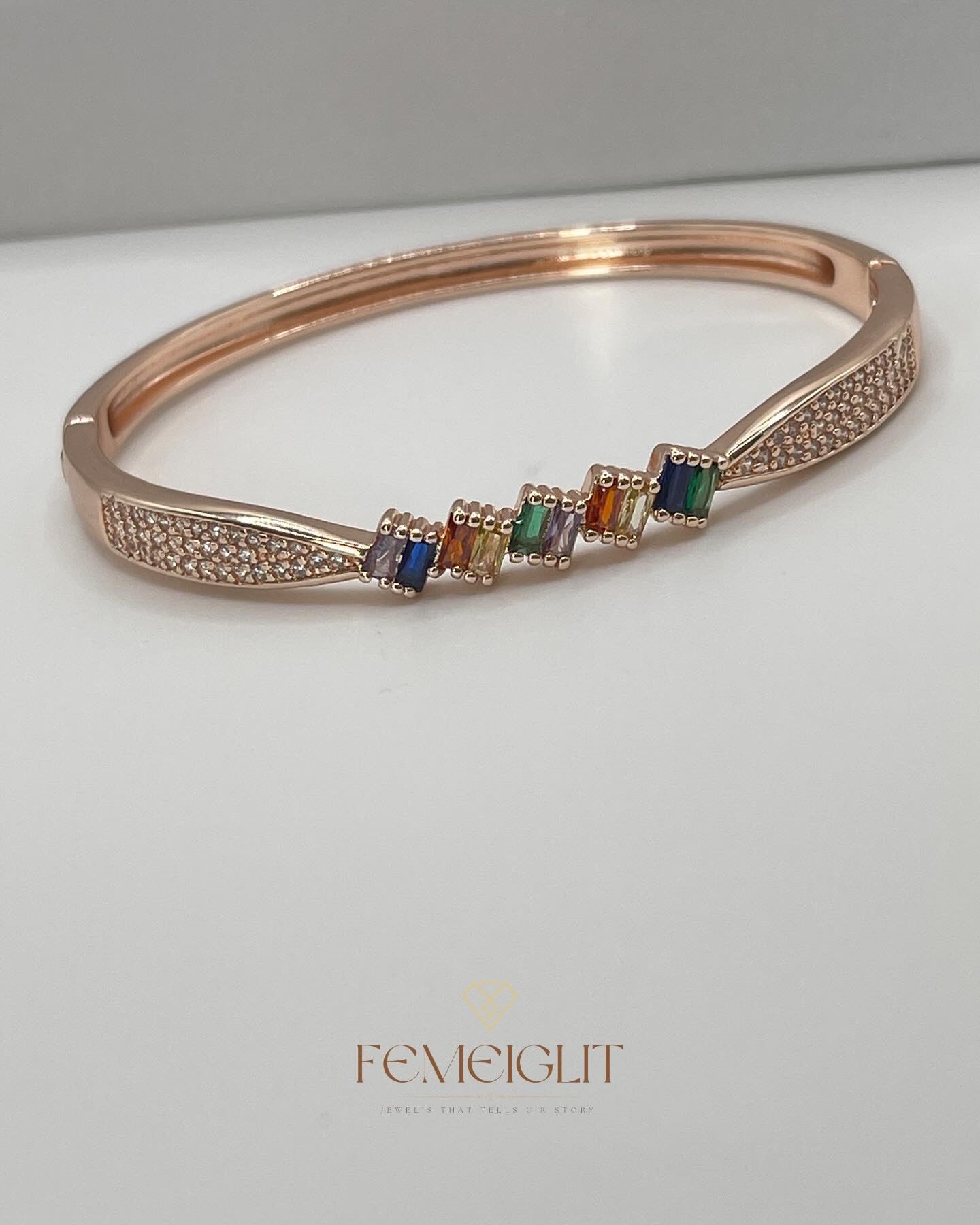 Rose gold bracelet with colorful beads on a white surface, featuring the brand 'Femeiglit'.