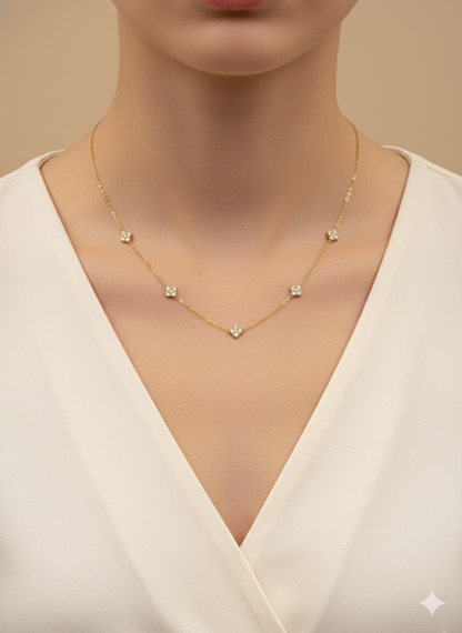 Gold necklace with small pendants on a model wearing a white top.