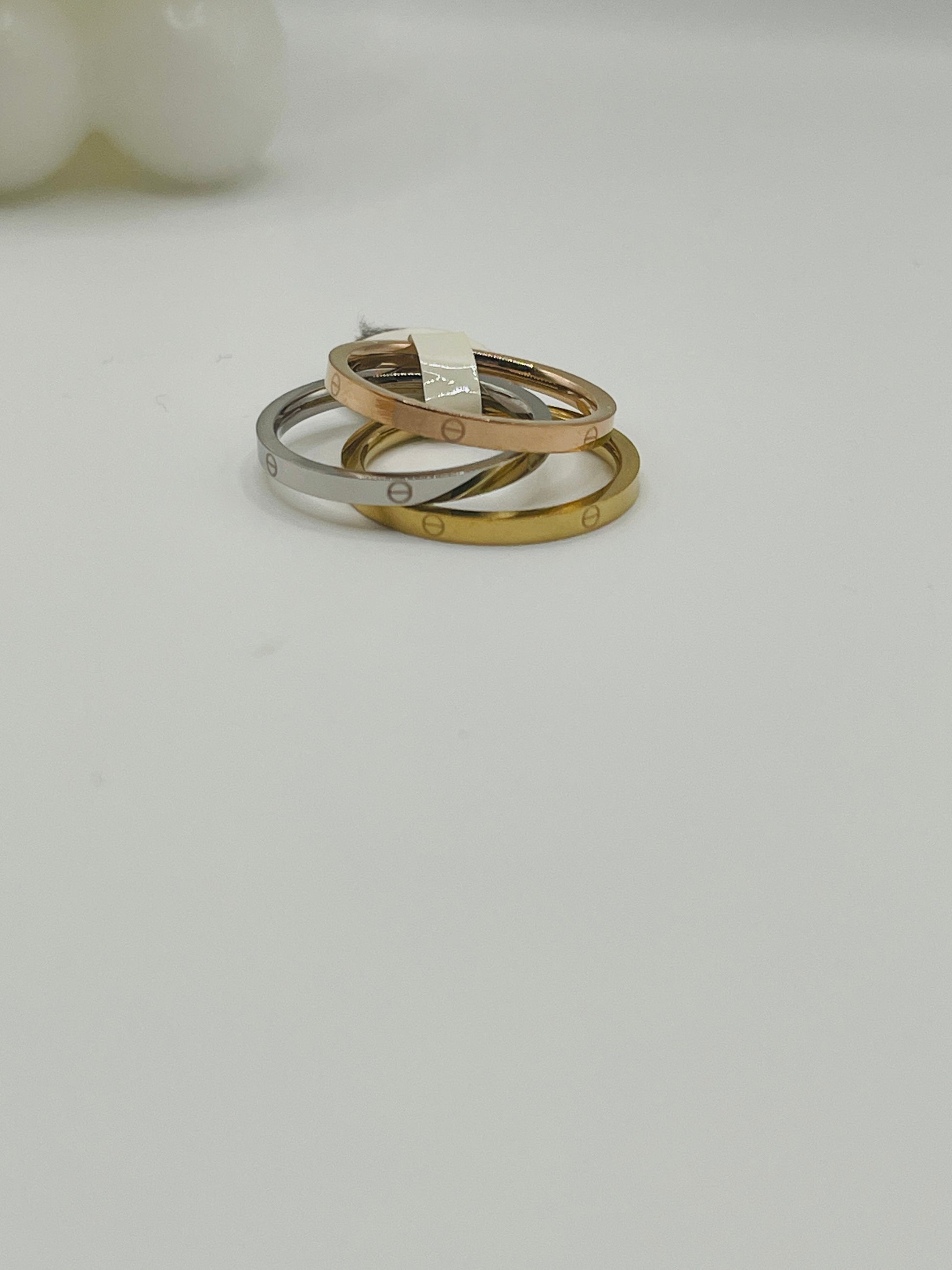 Three gold and silver rings stacked on a light gray background