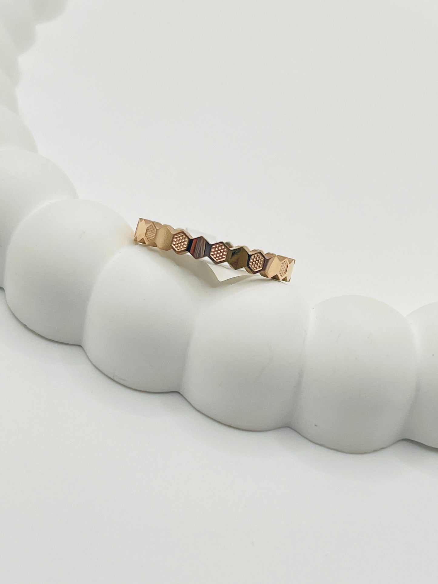 Rose Gold ring with geometric design on a white surface