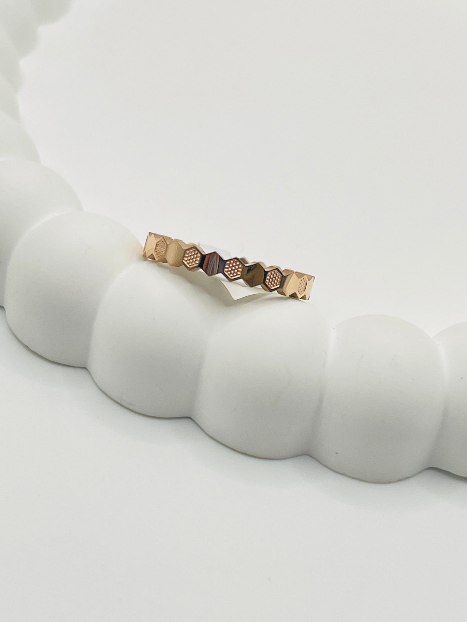 Rose Gold ring with geometric design on a white surface