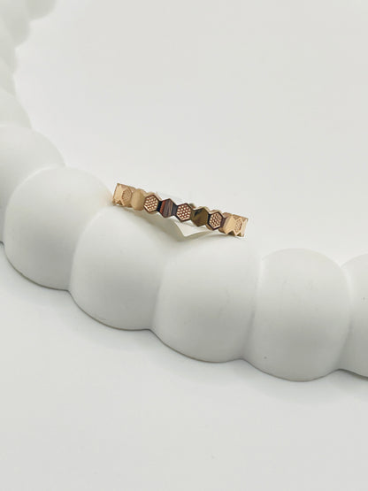 Rose Gold ring with geometric design on a white surface