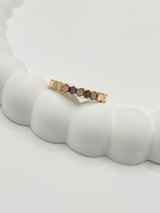 Rose Gold ring with geometric design on a white surface