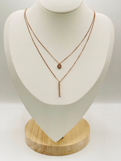 double layer Rose gold necklaces on a white mannequin bust with a wooden base.