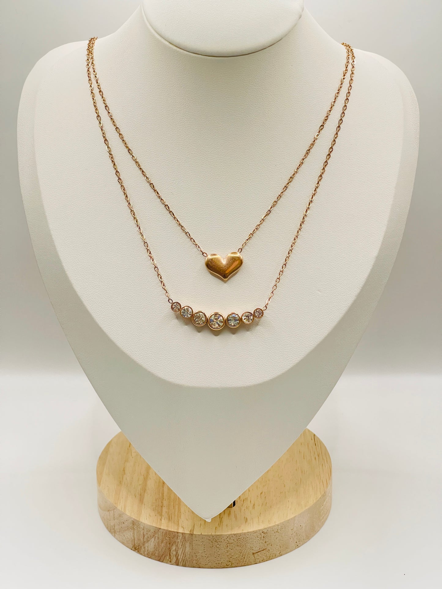 Gold necklace with a heart pendant on a white mannequin bust.