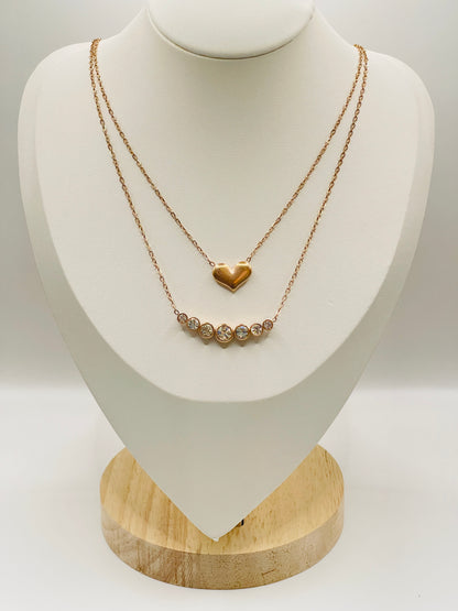 Gold necklace with a heart pendant on a white mannequin bust.