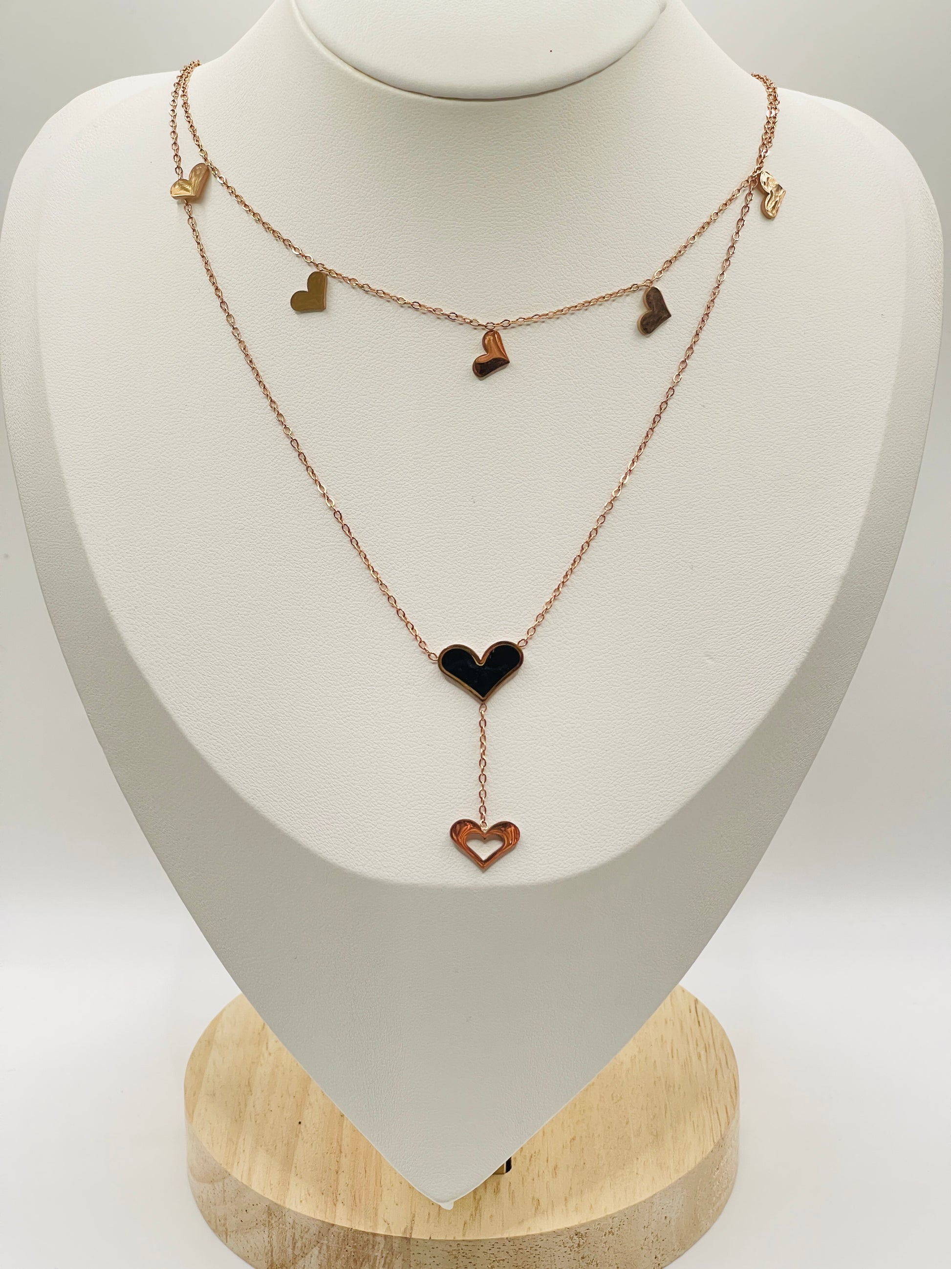 Rose gold Necklace with heart-shaped pendants on a white mannequin bust