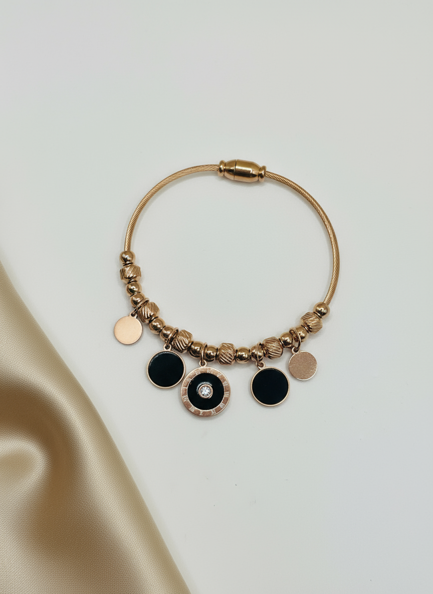 Rose Gold bracelet with black and rose gold charms on a light background