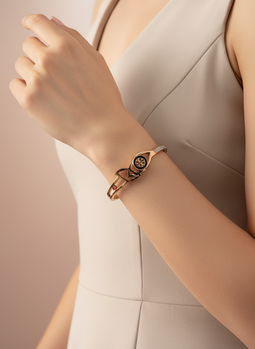 Rose gold bracelet with a bow design on a wrist against a neutral background