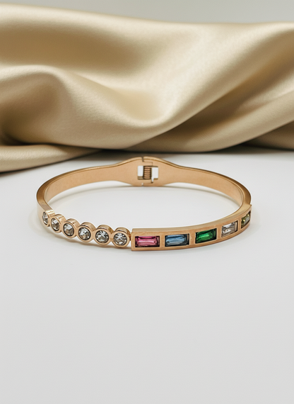 Rose Gold bracelet with colorful gemstones on a beige fabric background
