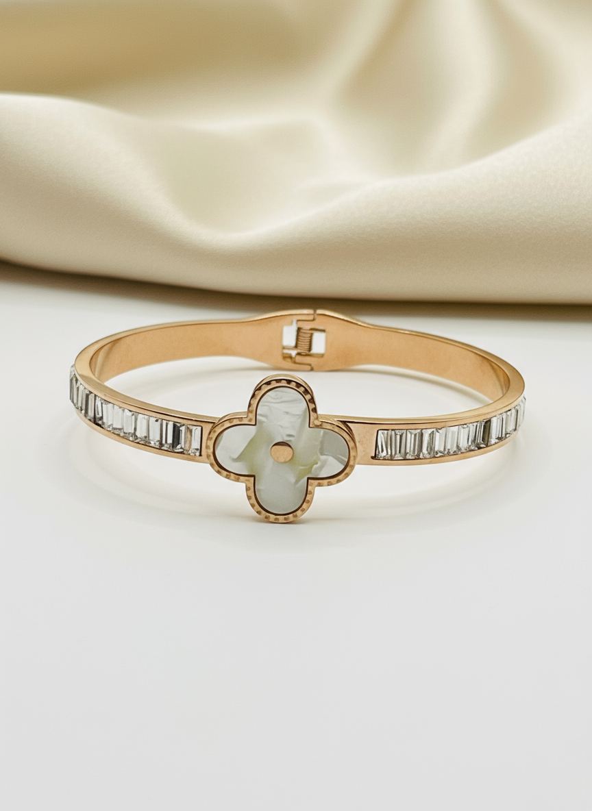 Rose Gold bracelet with a clover-shaped center and diamond accents on a beige fabric background