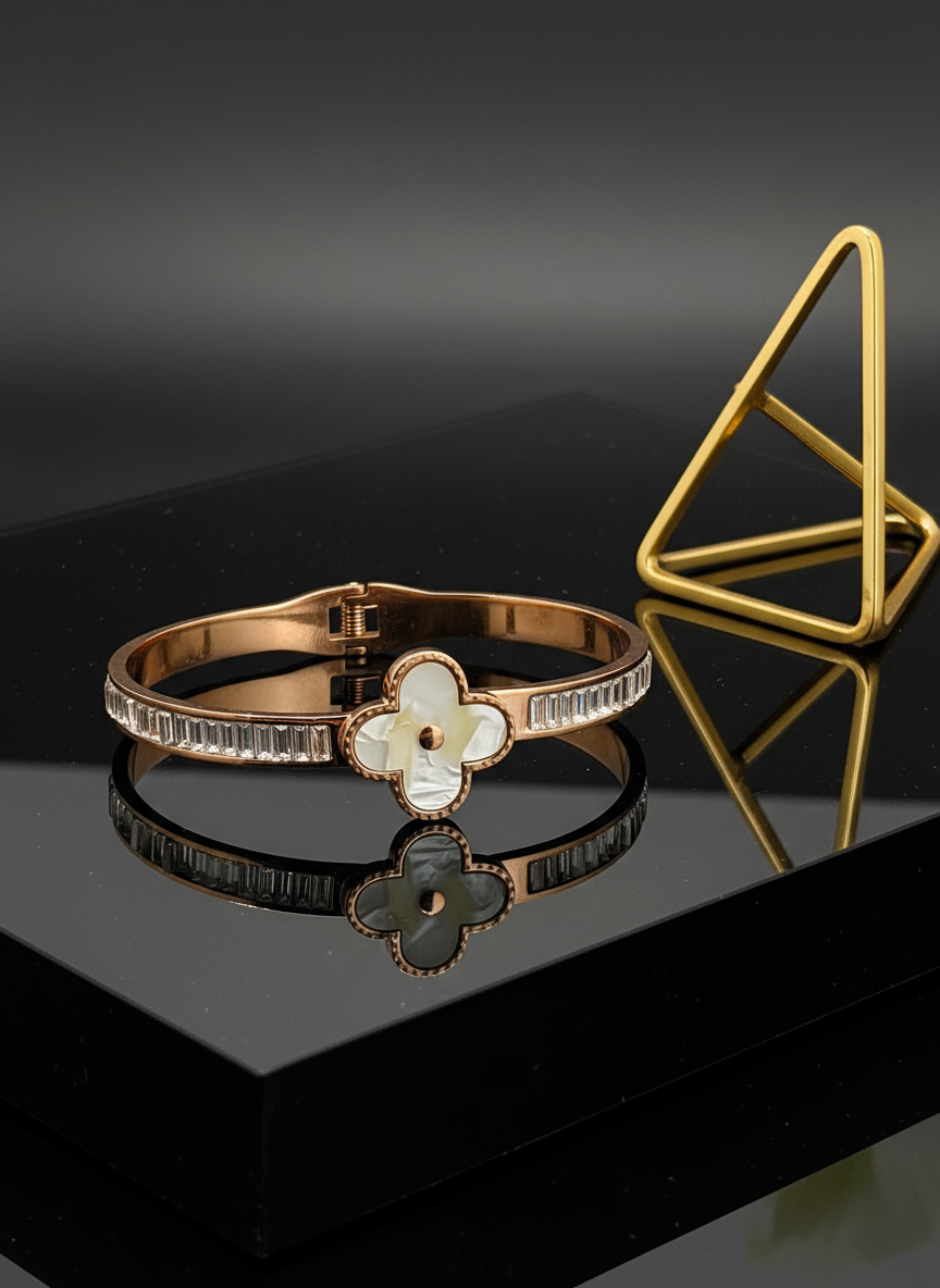 Rose gold bracelet with floral design on a reflective black surface