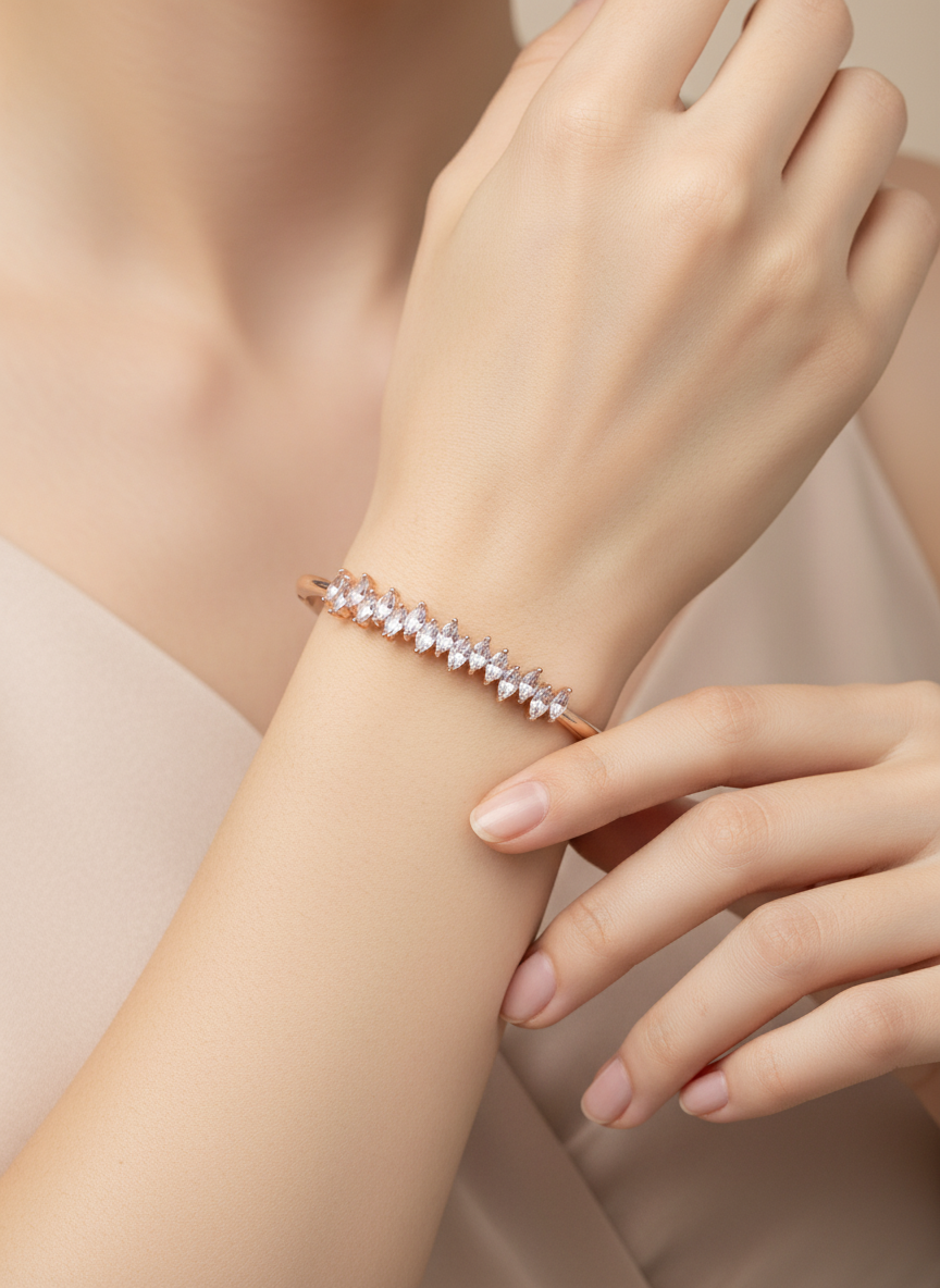 Rose gold bracelet on a wrist with a neutral background