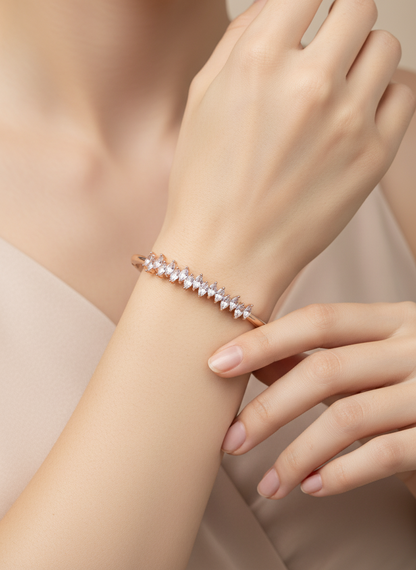 Rose gold bracelet on a wrist with a neutral background