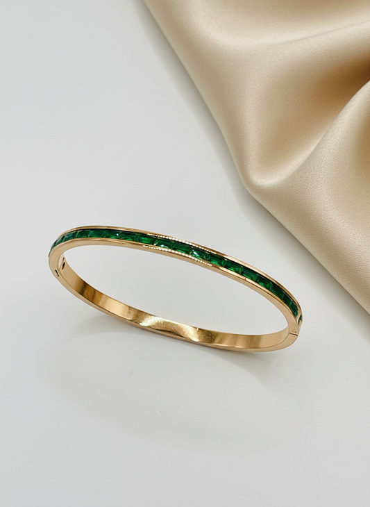 Rose Gold bracelet with green gemstones on a light background