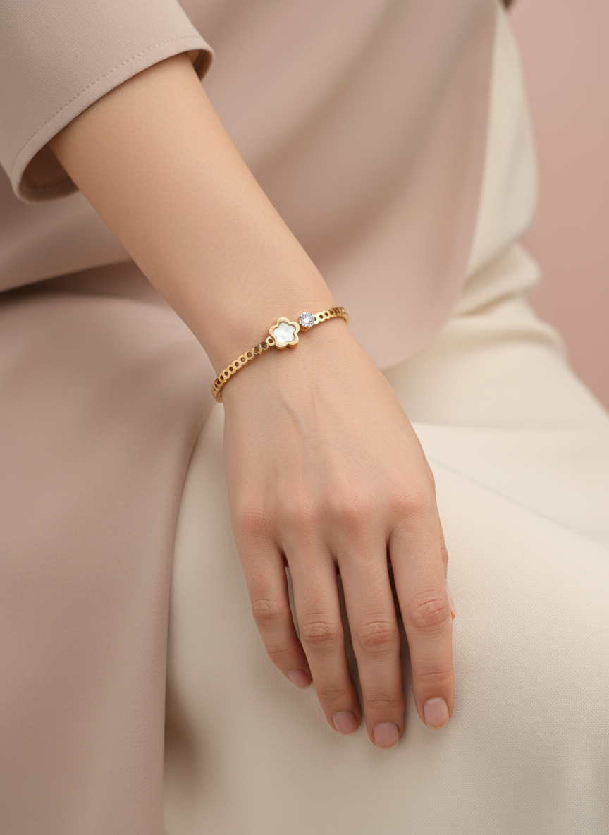 Rose Gold bracelet with a small round gemstone on a person's wrist against a neutral background