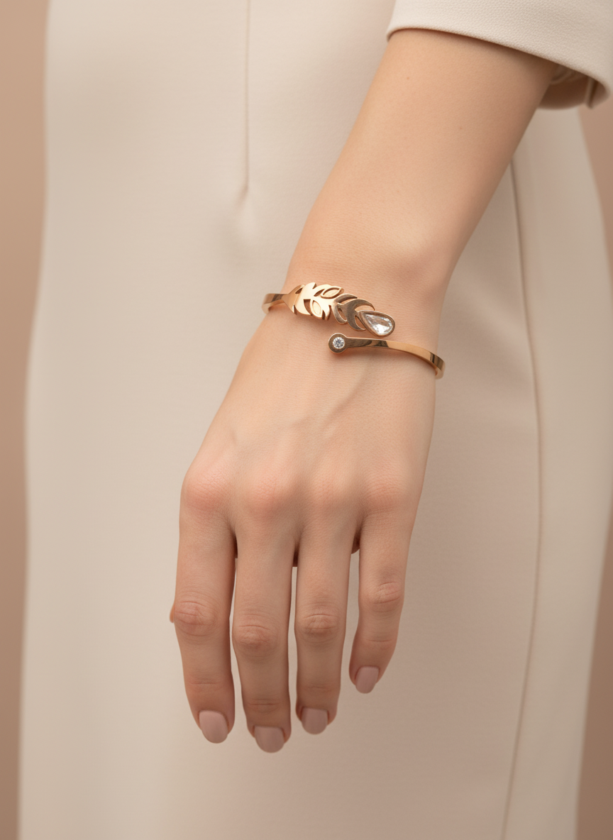 Rose gold bracelet with leaf design on a light gray background