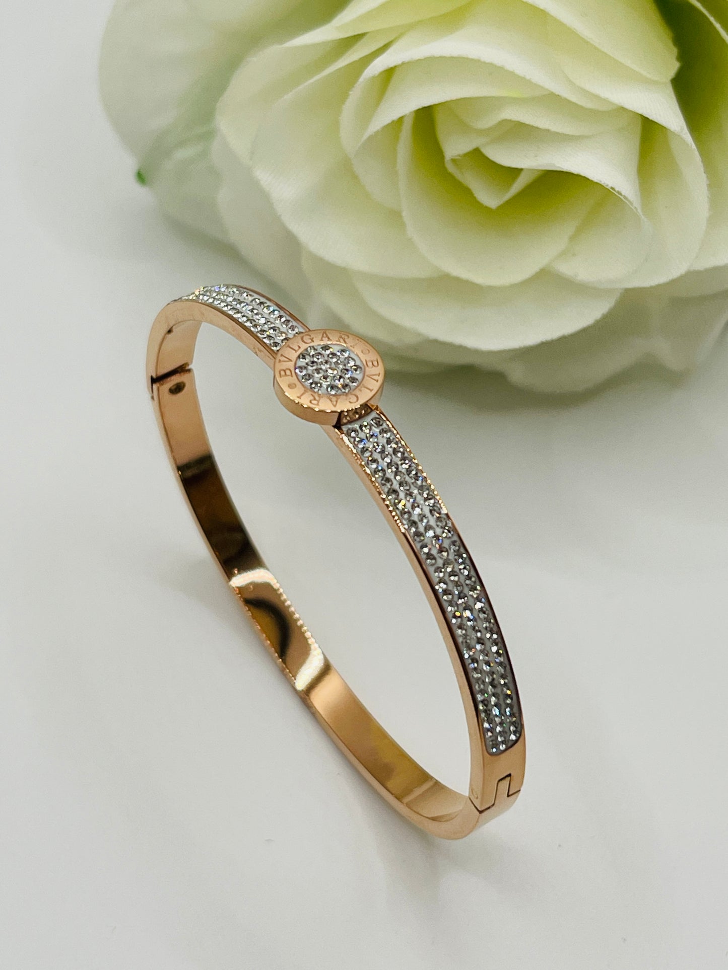 Rose gold bracelet with diamond accents on a light background